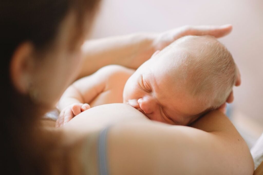 mother breastfeeding her baby child while holing in her arms